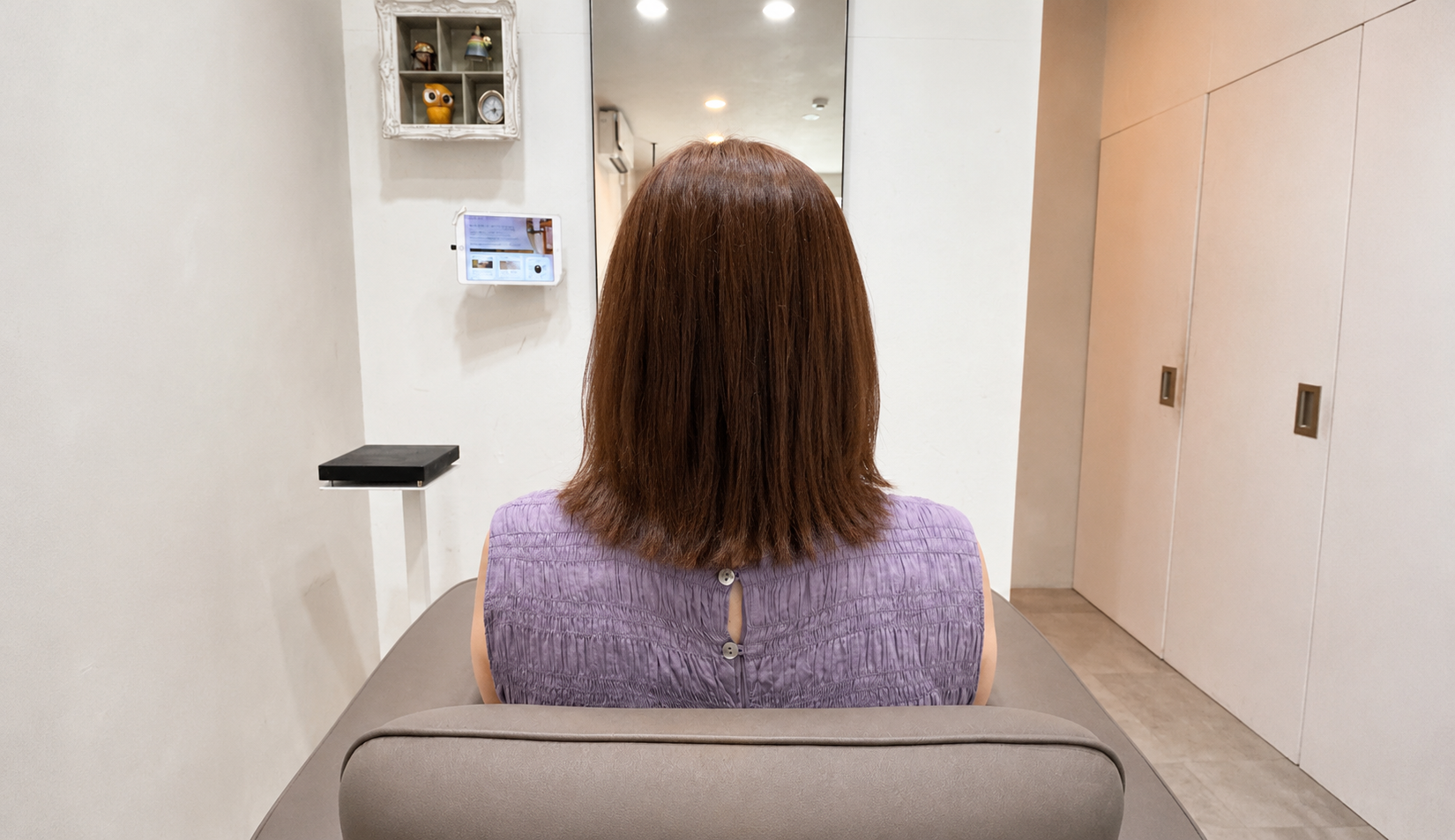初回のヘアマニキュア施術後、明るさを抑えて落ち着いたブラウンに整えた髪の後ろ姿